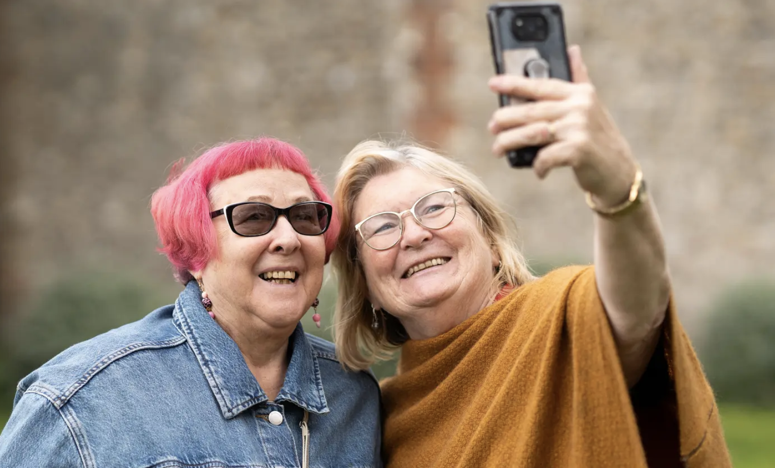 Picture of two older women, smiling and taking a selfie.