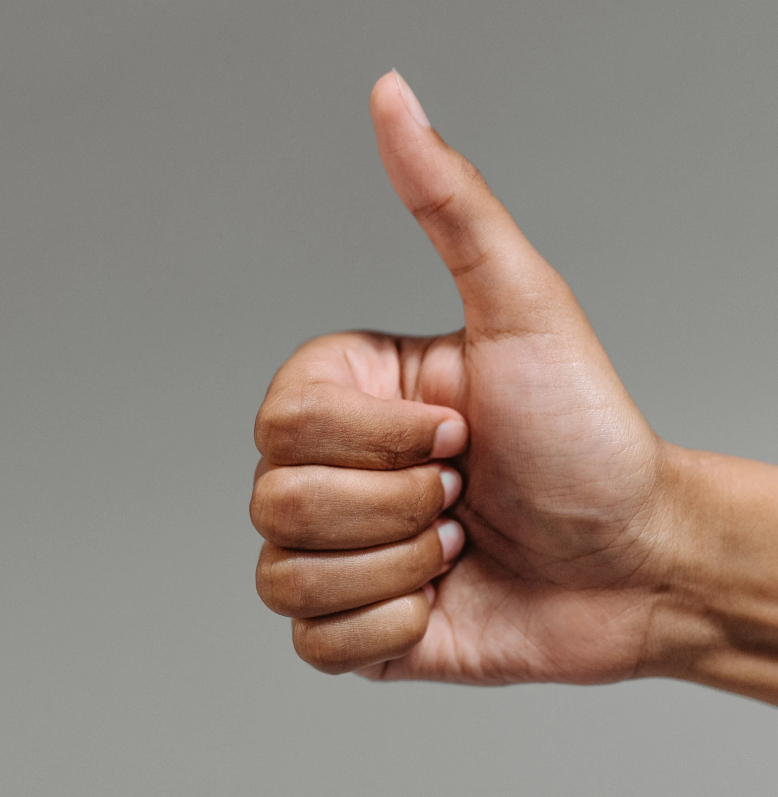 A human hand in a thumbs up position